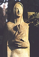 
   statue in the background   
       of a family's grave   
